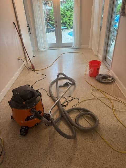 Wet vacuum extraction equipment and squeegee wand removing standing water from flooring
